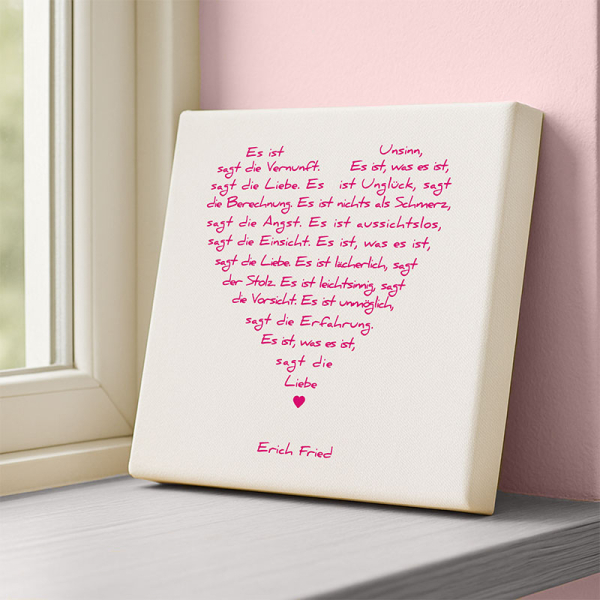 Leinwandbild Liebesgedicht Was es ist von Erich Fried in Weiss und Pink, an einer Wohnraum-Wand stehend