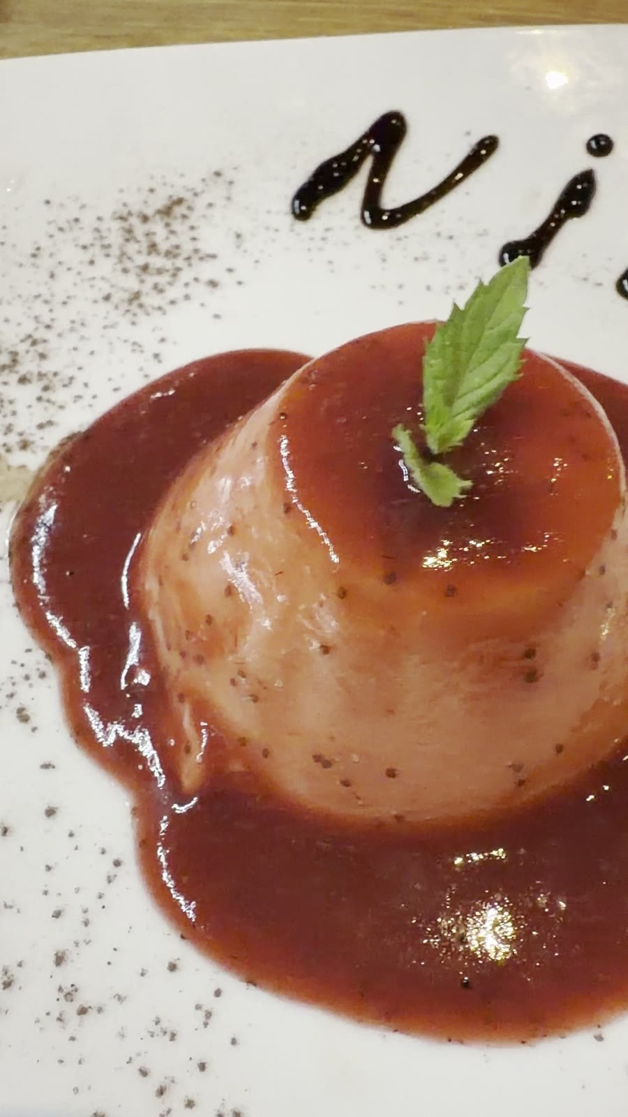 Dessert mit Beerensauce und Nino-Schokoladen-Signatur auf dem Teller bei Papanino Bremen