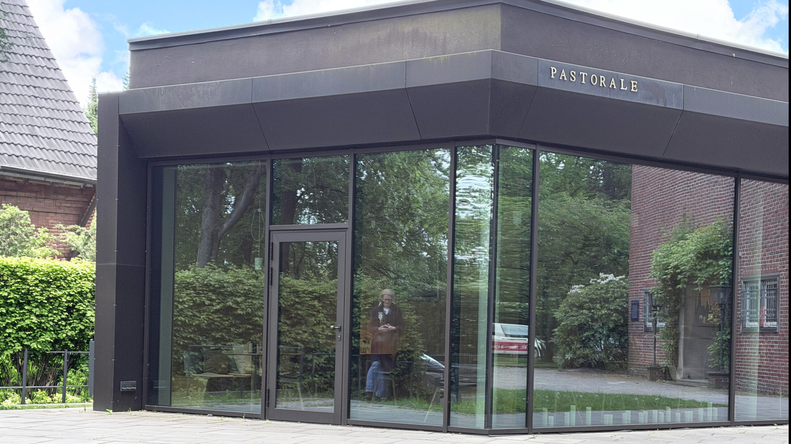 Pastorale Restaurant in Hamburg-Stellingen, schwarzer puristischer Bau mit Glasfassade und Schriftzug Pastorale
