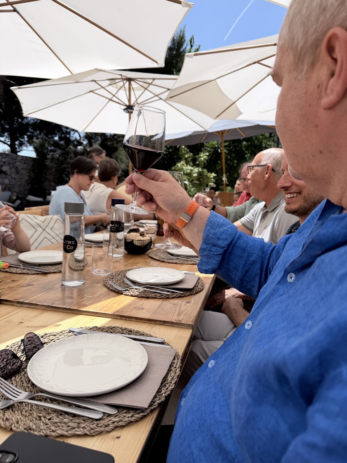 Rotwein-Anstossen an der langen Tafel mit Lume und Co Wasserflasche im Vordergrund