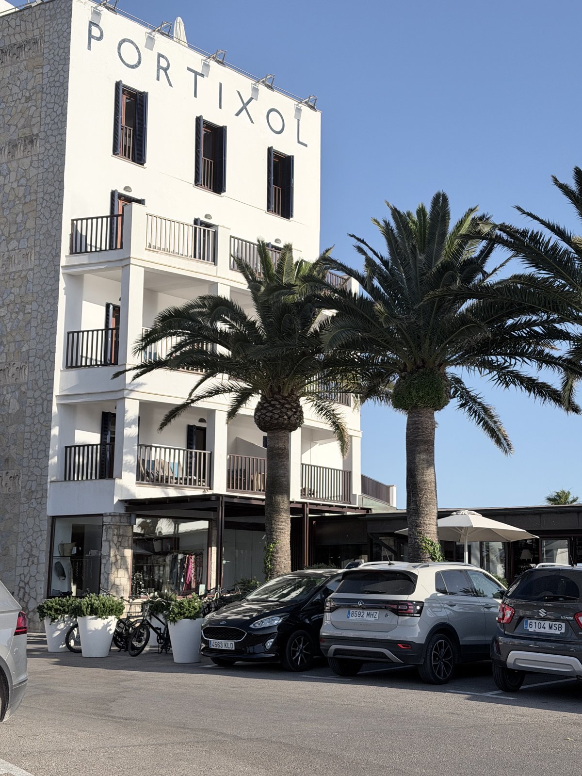 Weisse Fassade des Hotel Portixol in Palma de Mallorca mit Palmen am Abend
