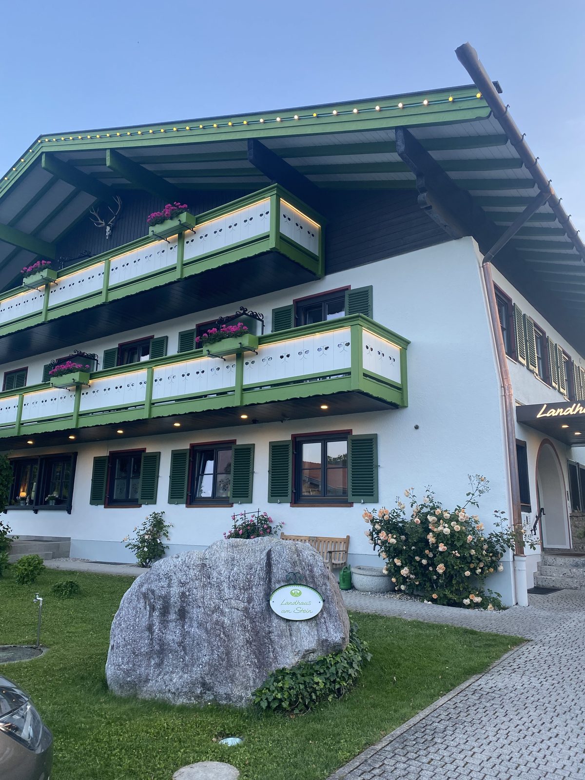 Hotelfront des Landhaus am Stein in Bad Wiessee mit dem namensgebenden Findling davor