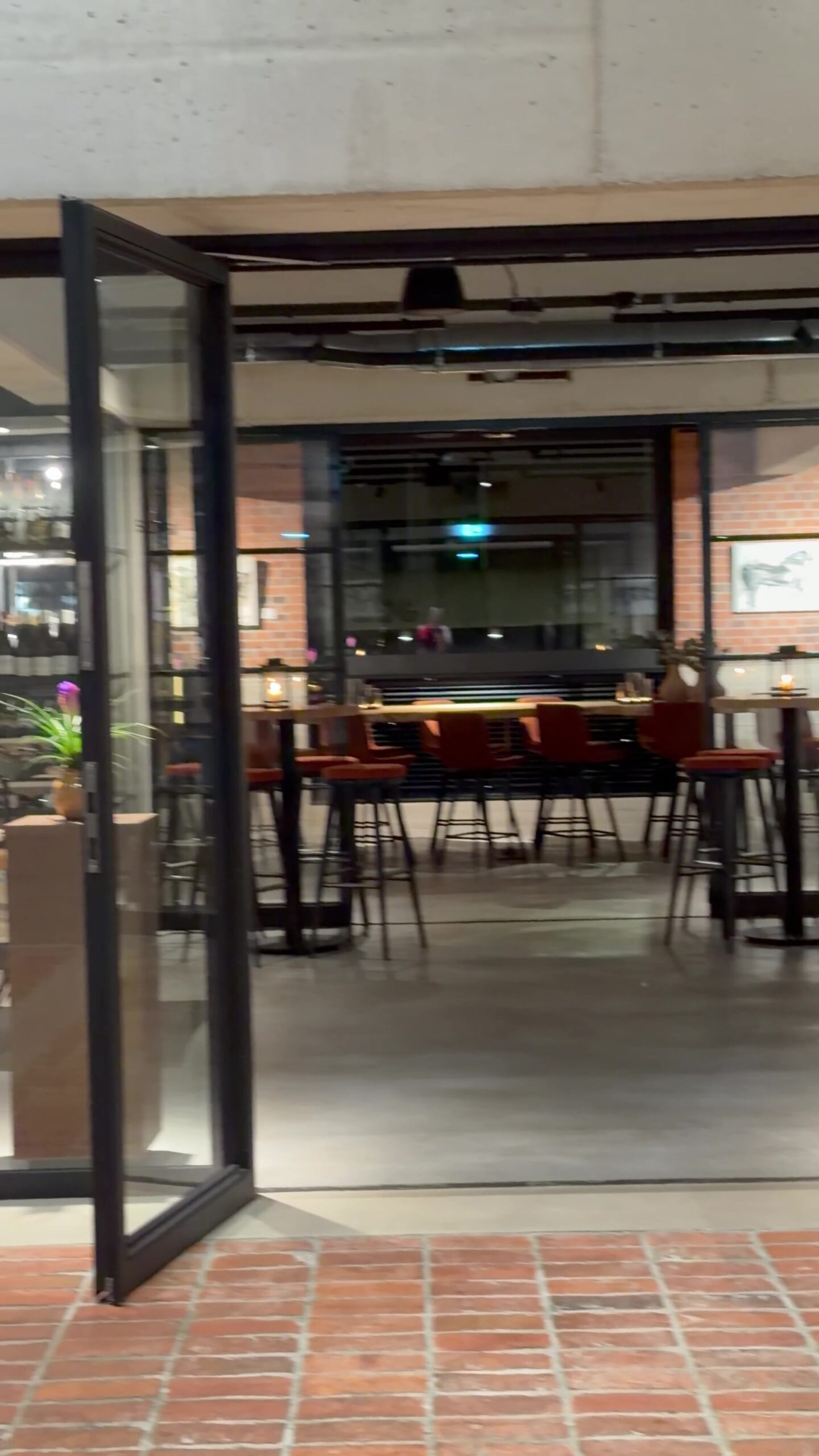 Bar at the back of Chefs Warehouse Hamburg with brick walls and rust orange bar stools
