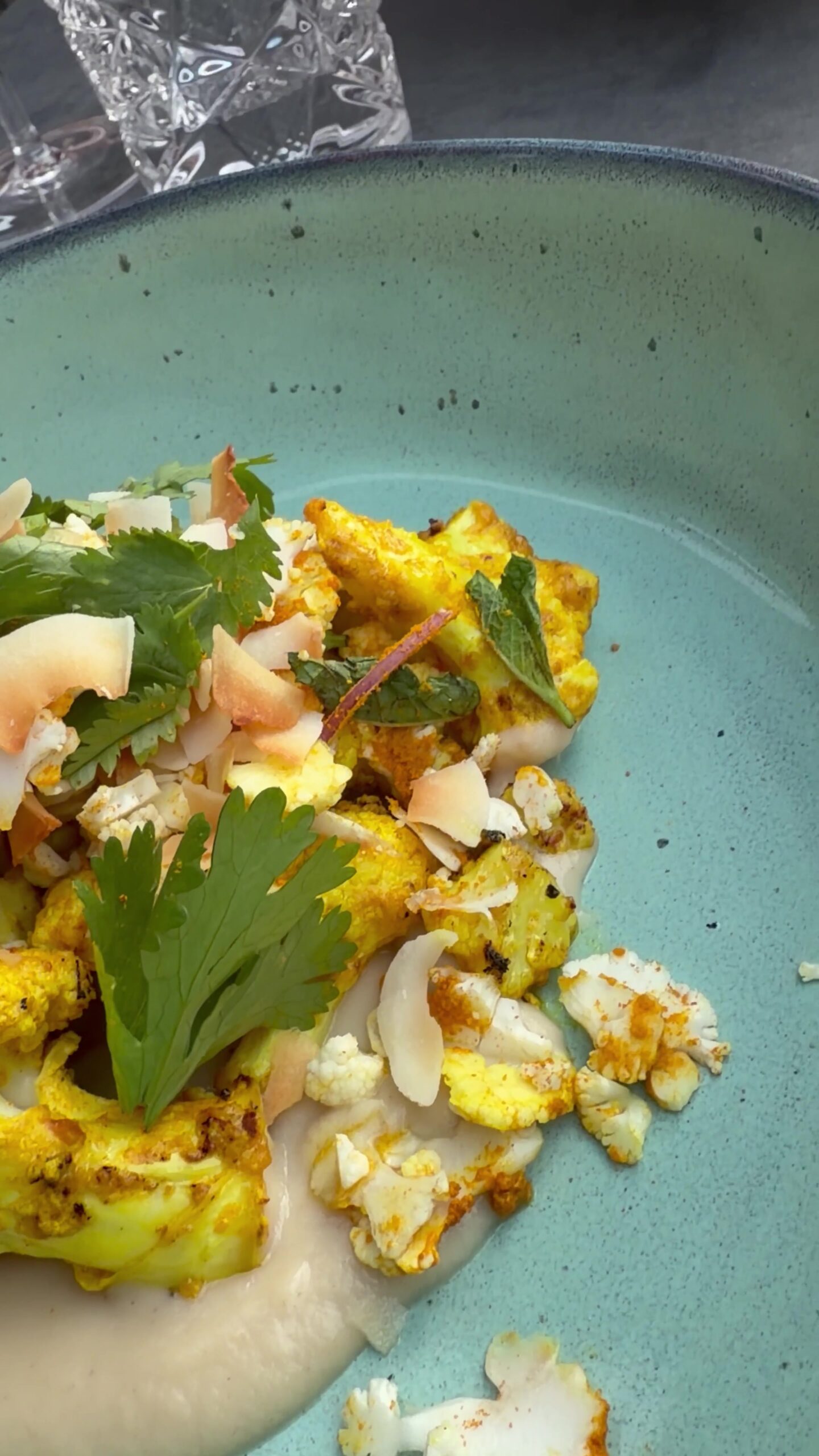 Tandoori cauliflower with coconut and fried curry leaves in a turquoise bowl at Chefs Warehouse Hamburg