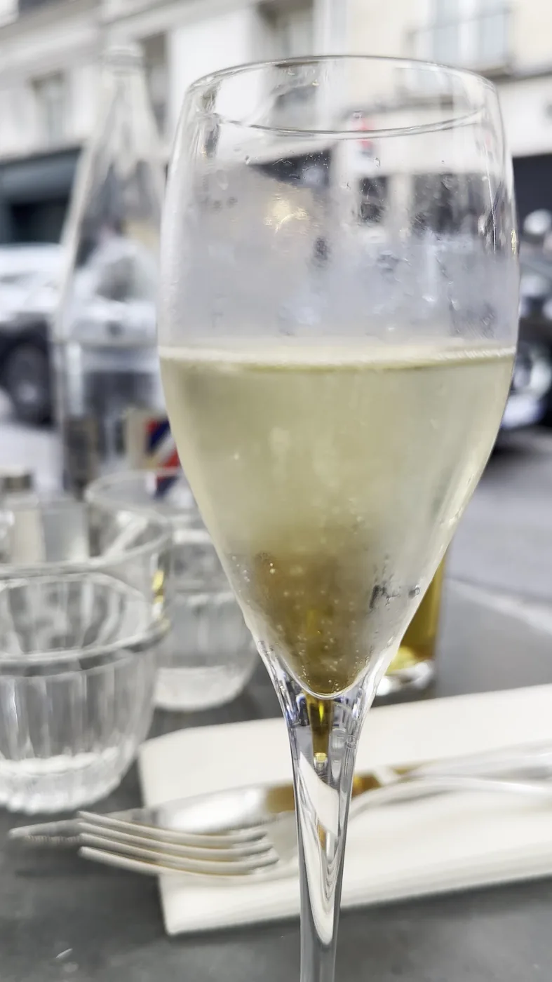 Glas auf einem Tisch auf der Terrasse des Les Antiquaires an der Rue du Bac in Paris