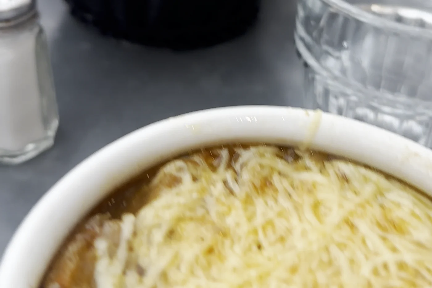Gratinierte Zwiebelsuppe mit Käsehaube im Restaurant Les Antiquaires in Paris