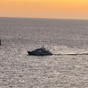 Boot im orangefarbenen Sonnenuntergang vor dem Restaurant Nautilus in Port de Sóller.
