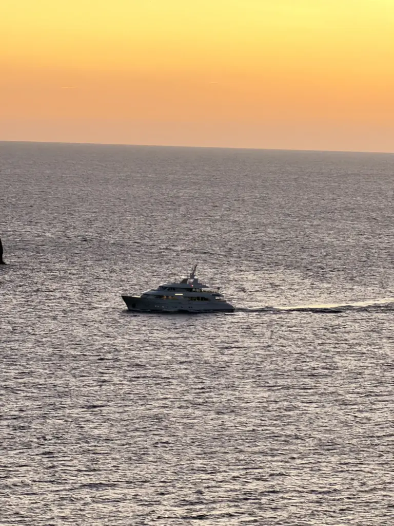 Boot im orangefarbenen Sonnenuntergang vor dem Restaurant Nautilus in Port de Sóller.
