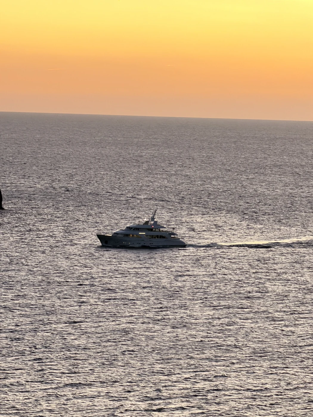 Boot im orangefarbenen Sonnenuntergang vor dem Restaurant Nautilus in Port de Sóller.