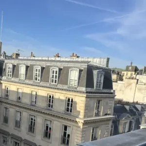 Blick von der Dachterrasse des Hôtel de l’Université über die Dächer von Paris mit Haussmann-Fassade und blauem Himmel