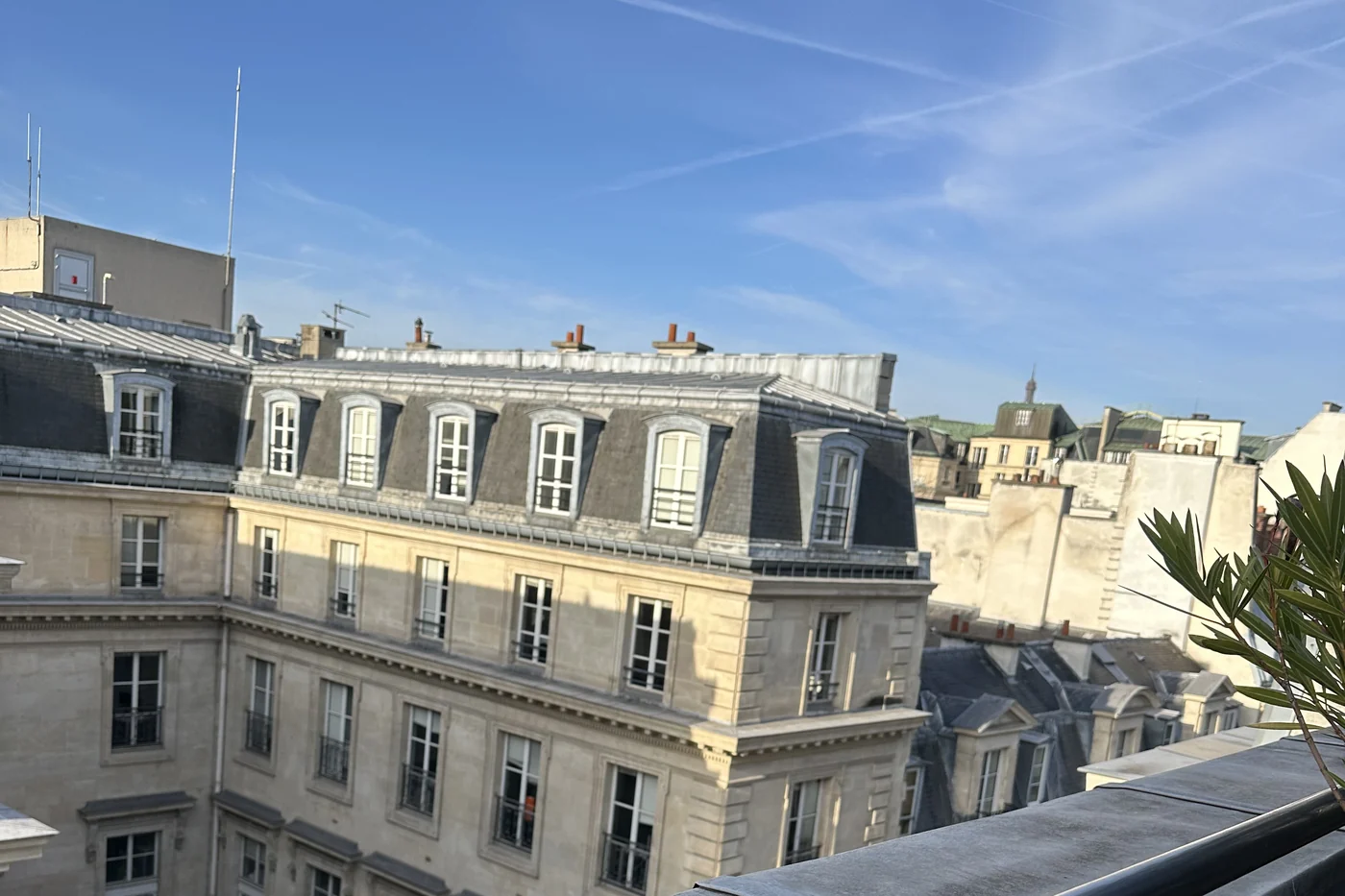 Blick von der Dachterrasse des Hôtel de l’Université über die Dächer von Paris mit Haussmann-Fassade und blauem Himmel
