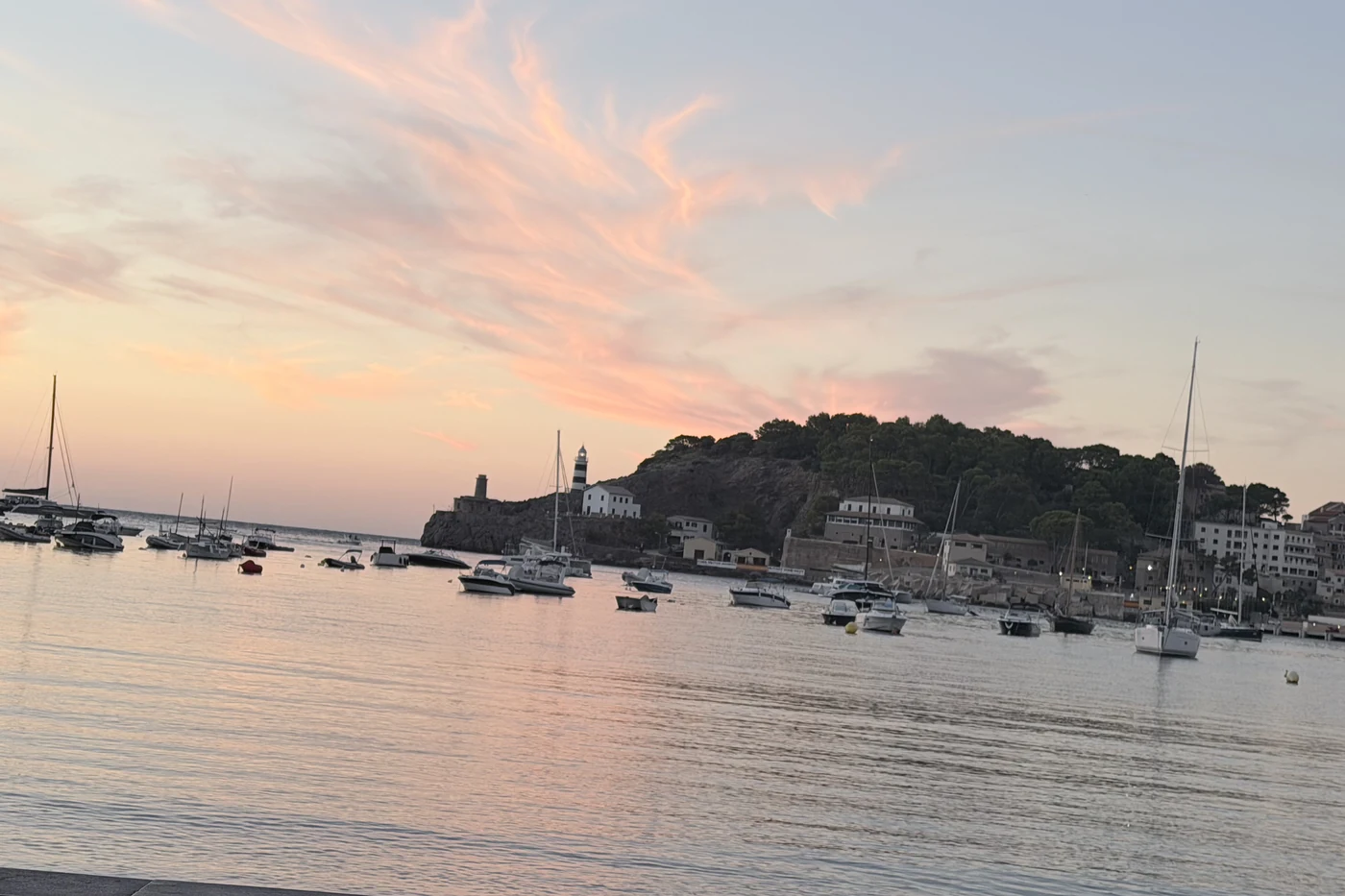 Die runde Bucht von Port de Sóller mit Booten und der Promenade im Abendlicht.