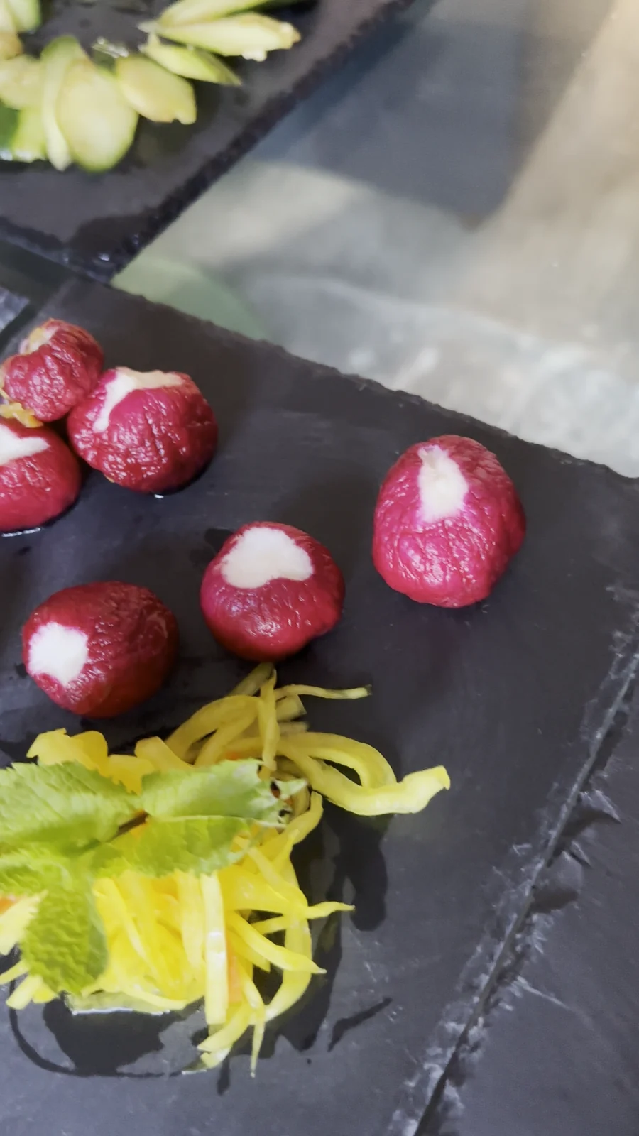 Slate boards with carved radishes, pickled ginger, mint and cucumber fans laid out in circles, catering by Michelle Wong