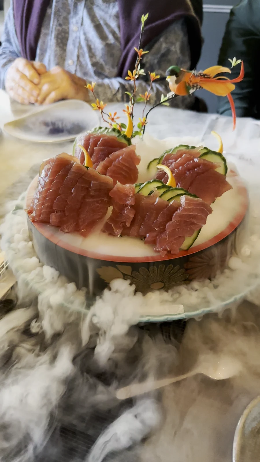 Thunfisch-Sashimi auf der Glasplatte, weißer Rauch vom Trockeneis läuft über die Tischkante, im Restaurant Wong Hamburg