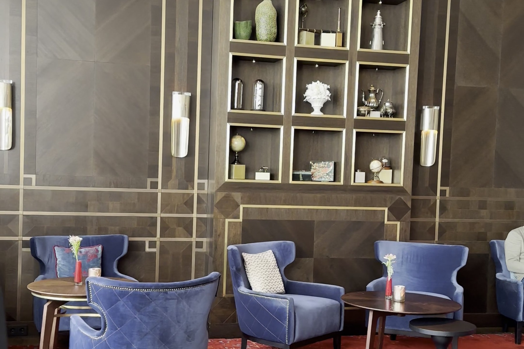 Blue armchairs and low tables in the bar area of Hotel Atlantic in daylight, photographed in 2024.