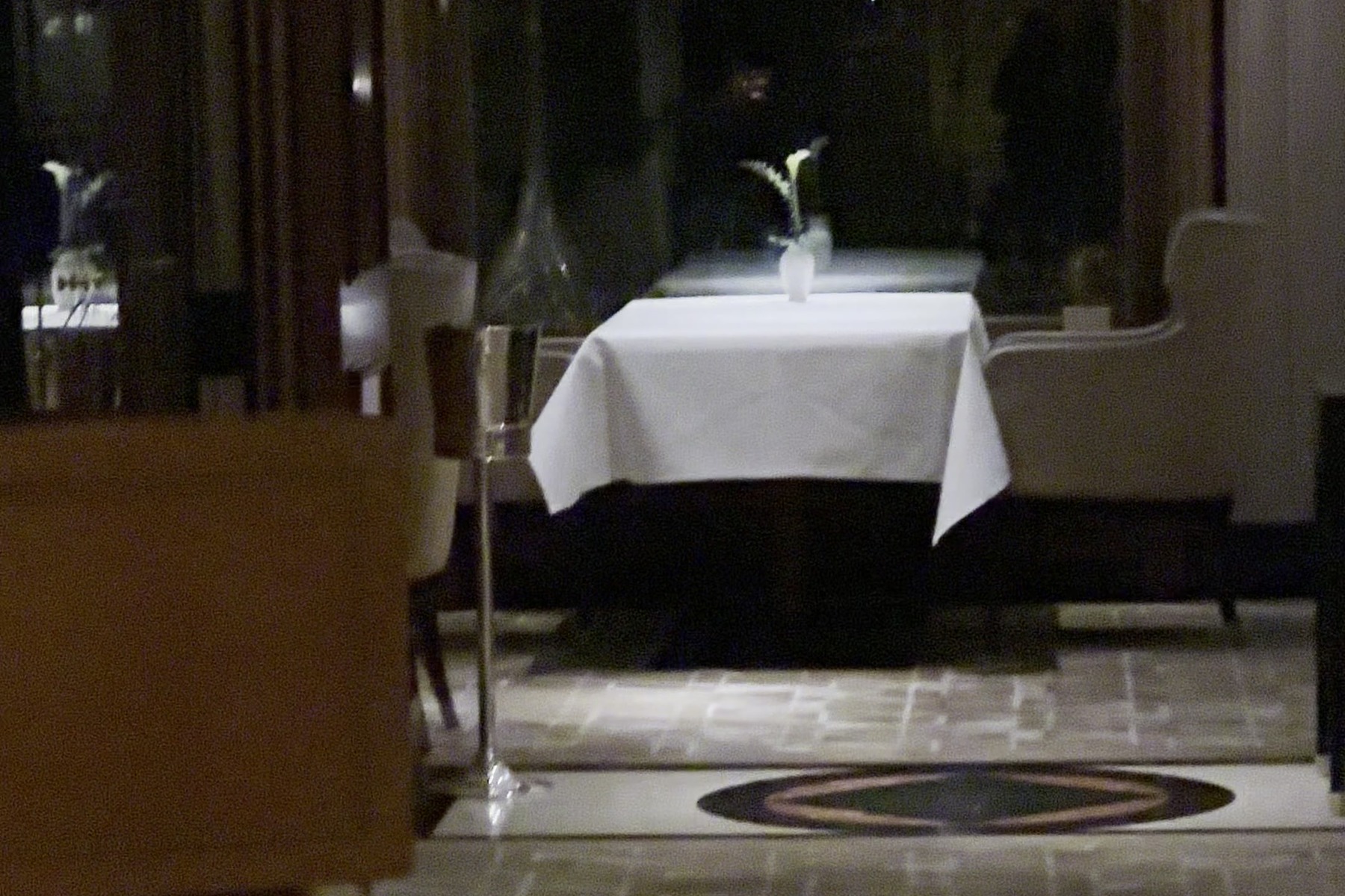 A quiet part of the restaurant at the end of the evening, laid tables and warm light.