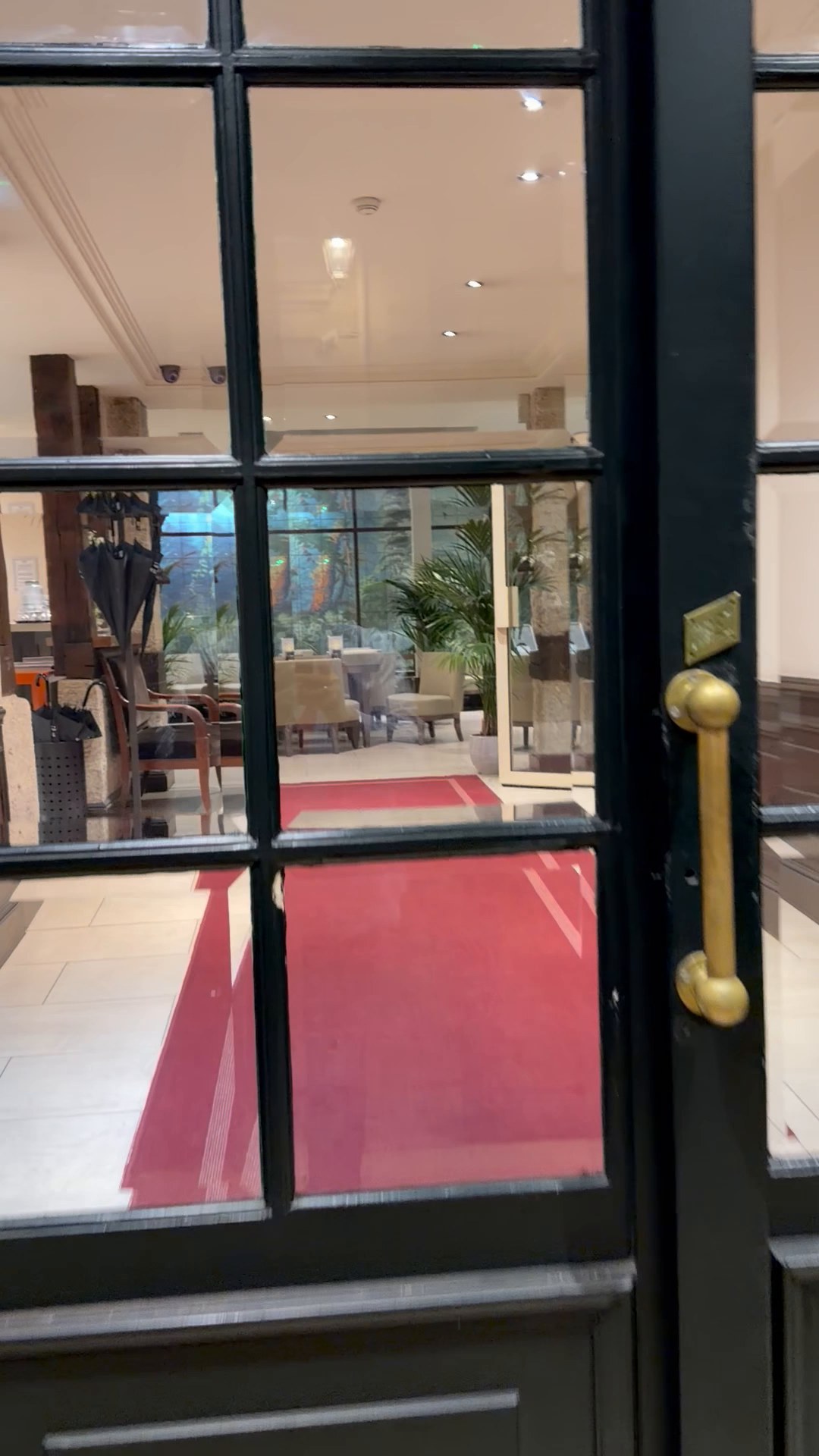 Lit entrance of the Hôtel de l'Université with a red runner.
